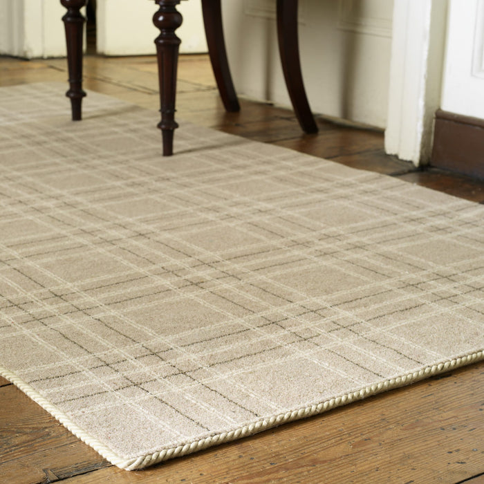 carpet edge binding in beige on a tartan rug with wooden chair