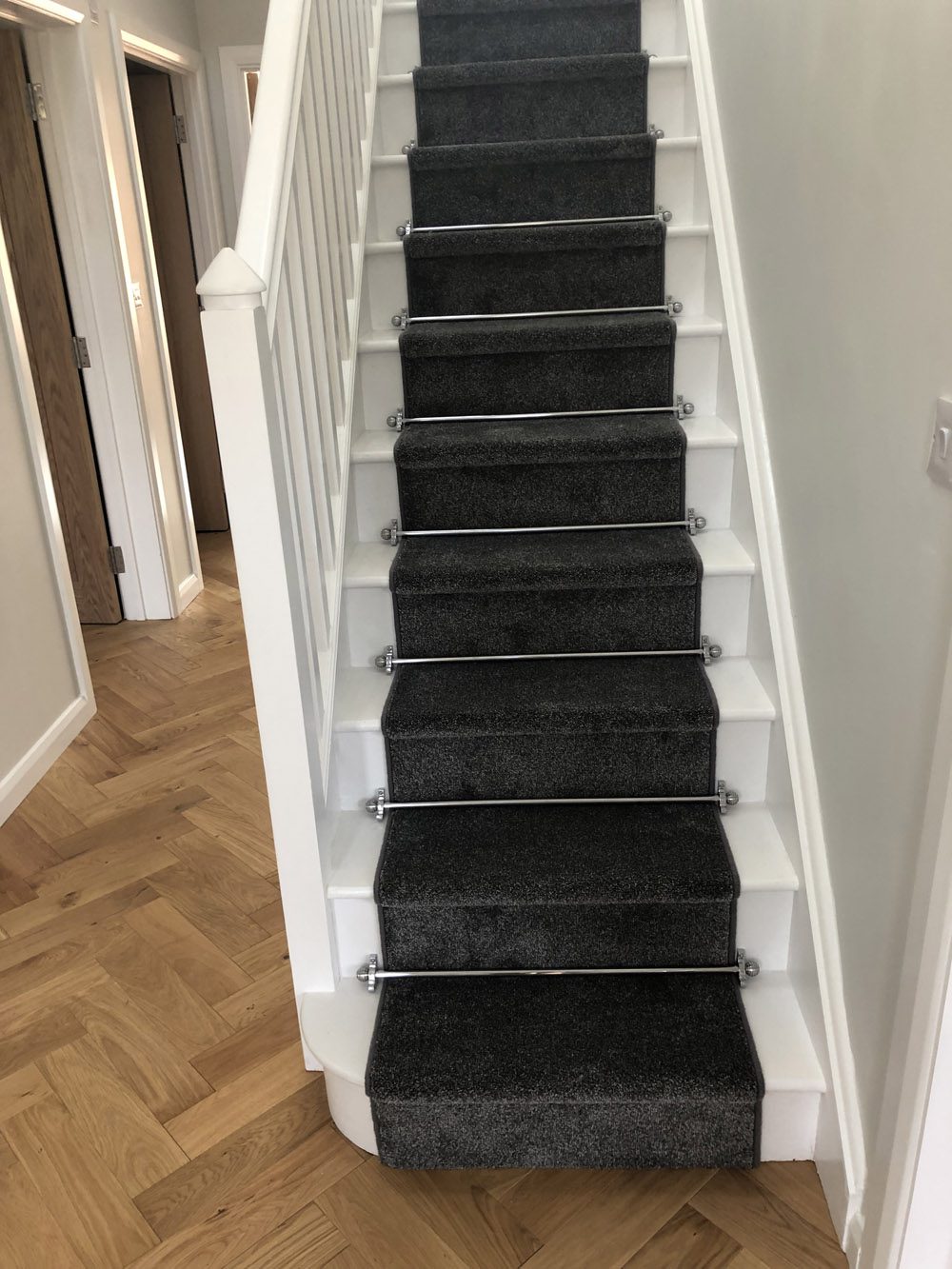 Polished chrome stair rods with sphere finials on teal stair runner