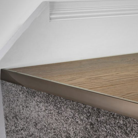 laminate stair nose in antique joins laminate to carpet riser