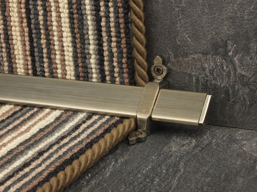 Vue stair rods in polished brass on striped carpet