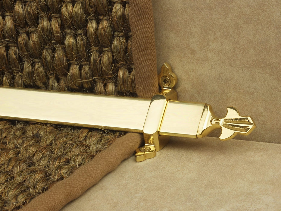 Louis design of stair rod with fleur-de-lys end, antique brass on red carpet