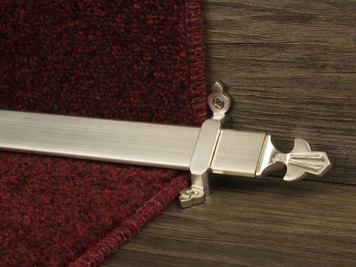 Louis design of stair rod with fleur-de-lys end, antique brass on red carpet