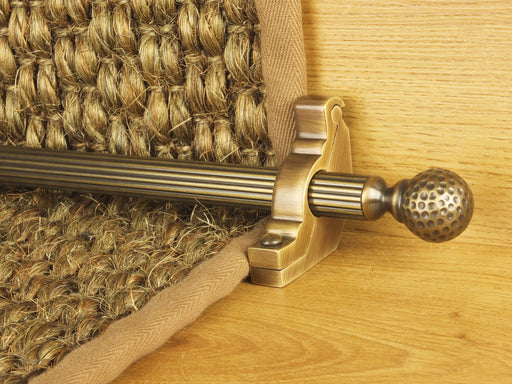 Extra large Dune stair rods on striped carpet