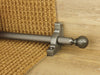 Extra large Dune stair rods on striped carpet