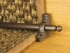 Windsor stair rod in antique bronze shown on seagrass runner